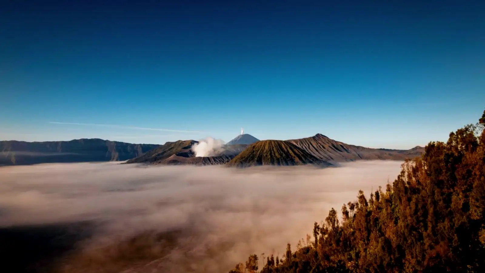 Mount Bromo Crater Detail Close-up of the smoking Mount Bromo crater with blue sky