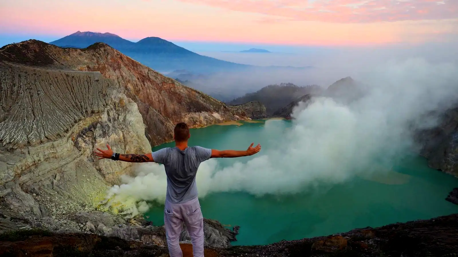 ijen crater photography tips for landscape enthusiasts - Sunrise Lake - The sun rising over the turquoise lake with orange light hitting the crater walls