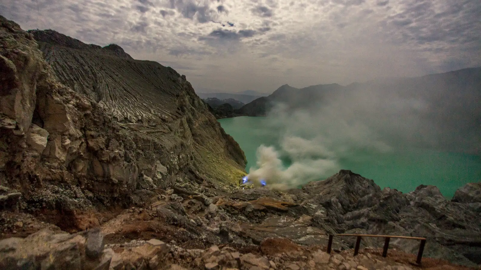 Ijen Crater sunrise view with turquoise acidic lake and volcanic steam