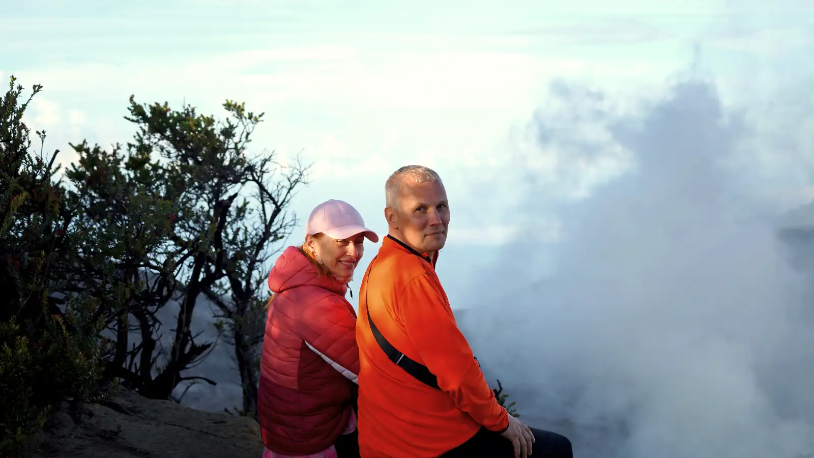 Hikers standing on the edge of Ijen Crater rim during the golden hour