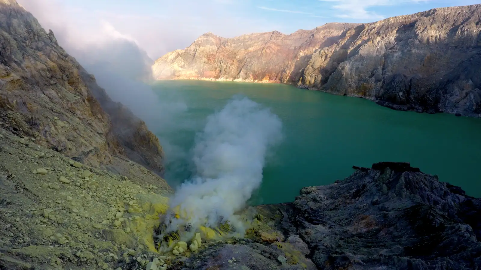 Ijen Sulfur Miners and Volcanic Activity Local sulfur miners at Mount Ijen carrying heavy baskets of sulfur through the volcanic smoke