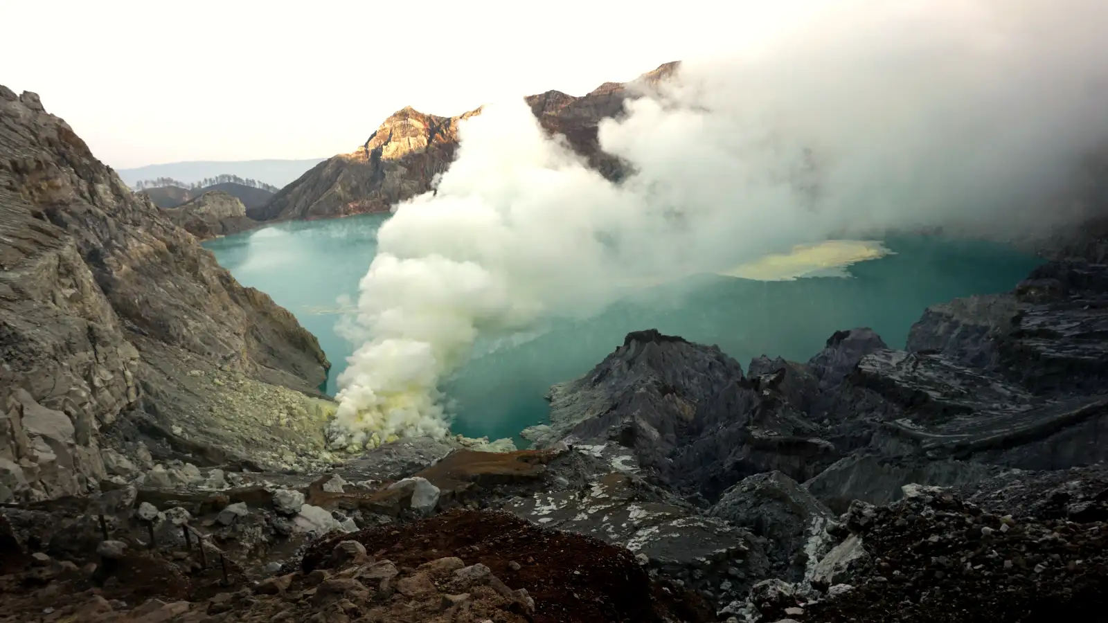 Ijen Sulfur Miners Ground Reality Sulfur miners carrying baskets near the Ijen crater floor