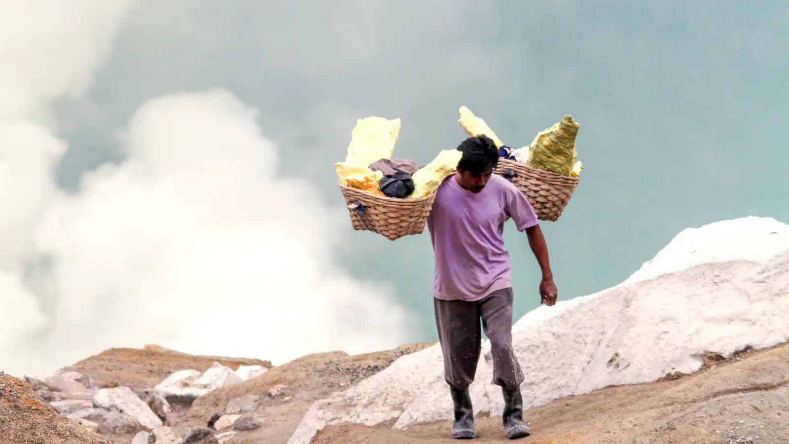 The Acidic Beauty of Kawah Ijen The teal acidic lake of Ijen Crater with sulfur smoke