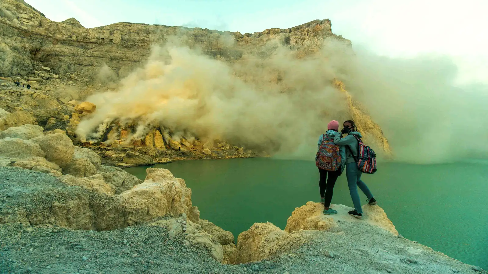 Hikers wearing volcanic gas protection at Ijen Crater during a night trek to see the blue fire